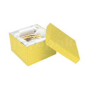 Estuche cuadrado alto dorado con almohadilla interior para exhibir un reloj o brazalete.