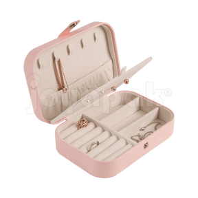 Alhajero de viaje texturizado color rosa pastel con cierre, abierto mostrando compartimentos para anillos y aretes con joyería colocada.