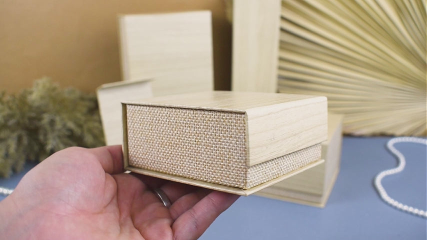 video mostrando la caja burlap de Joyapak en sus dos colores y tamaños disponibles