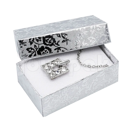 Caja Fiore chica plateada sosteniendo un broquel de plata para mostrar su tamaño y elegancia.
