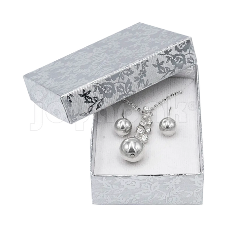 Un coordinado de collar y aretes de plata presentado dentro de la caja Fiore mediana abierta.