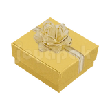 Caja de cartón color turquesa para aretes chicos de la línea Fashion con un moño decorativo en la tapa.