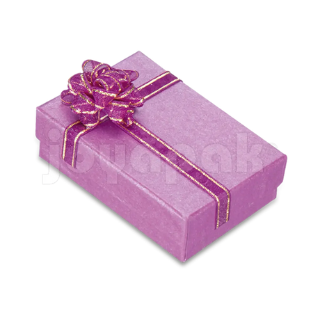 Caja de cartón rectangular para juego de aretes y dije color rosa de la línea Fashion, con moño decorativo.