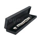 Estuche Italia de color negro con marco interior dorado estrecho para pulsera, caja abierta alargada mostrando una pulsera fina colocada sobre terciopelo blanco.